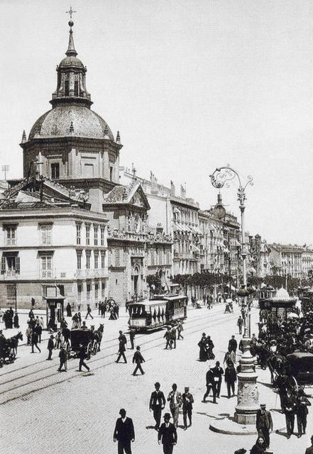 Foto antigua de la Iglesia de la Concepción Real de Calatrava con tranvías, carros con caballos y gente caminando