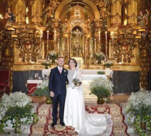 Dos novios felices posando recién casados en la Iglesia de la Concepción Real de Calatrava