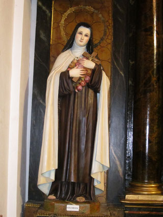 Imagen de Santa Teresita del Niño Jesús sosteniendo un rosario grande en los brazos en la Iglesia de la Concepción Real de Calatrava