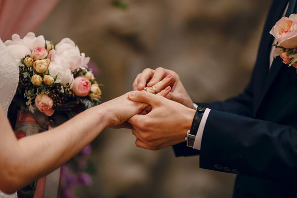 Hombre poniendo el anillo de boda a su esposa