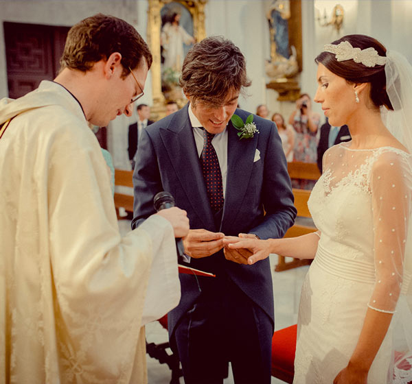 Fotografía de un sacerdote celebrando una boda con los novios poniéndose los anillos en la Iglesia