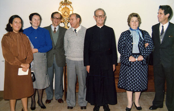 El Padre Tomás Morales junto a miembros de los Hogares de Santa María, sonriendo y compartiendo un momento de camaradería.