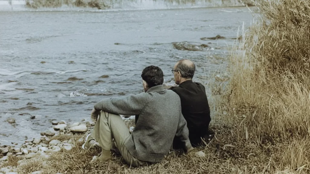 Padre Tomás Morales sentado junto al río dando dirección espiritual a un militante