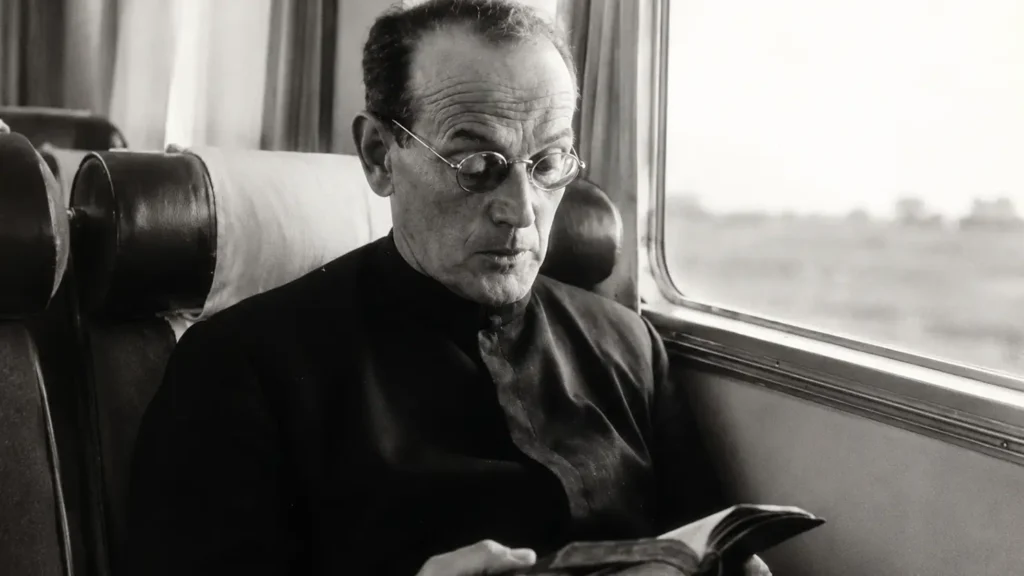 El Venerable Padre Tomás Morales S.J. leyendo durante un viaje en tren, fundador de los Cruzados de Santa María y Hogares de Santa María.
