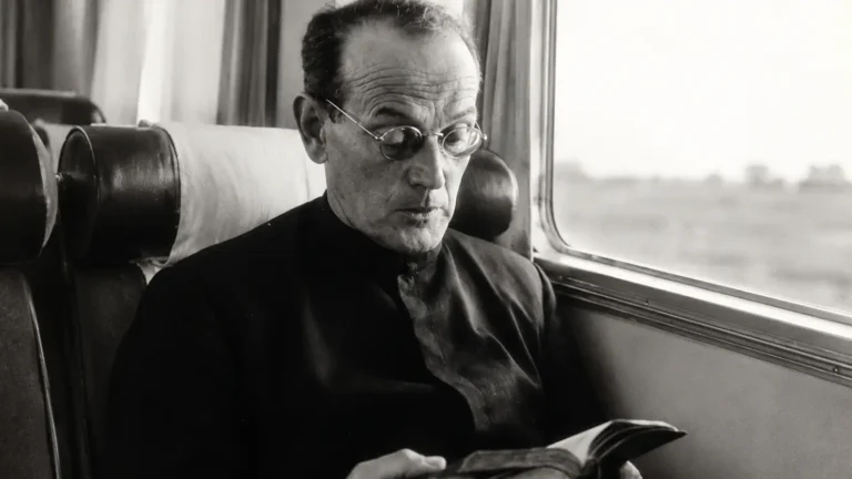 El Venerable Padre Tomás Morales S.J. leyendo durante un viaje en tren, fundador de los Cruzados de Santa María y Hogares de Santa María.